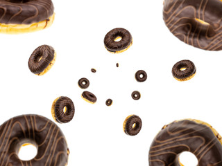 Falling chocolate donuts isolated on white background. Sweet sugar icing donuts.