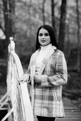 Fashion autumn portrait of stylish model woman, posing. Woman posing in park in warm coat, autumn fashion trend. Beautiful young teen girl 