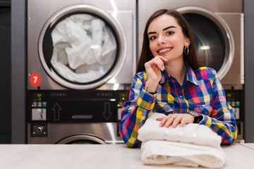 Satisfied laundry client against the background of dryers 