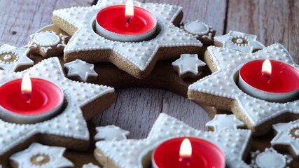 Xmas advent wreath of star-shaped gingerbread with red tea candles
