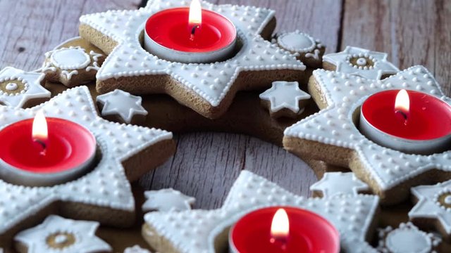 Xmas advent wreath of star-shaped gingerbread with red tea candles