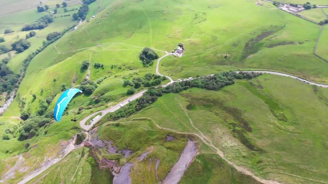 Aerial drone view of parashute jumper flying on the background of wild nature.