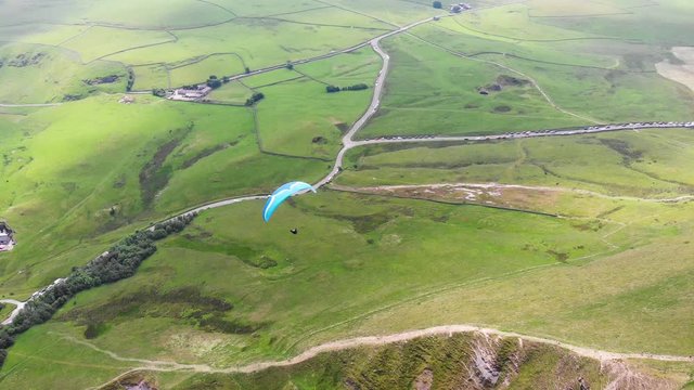 Paraplan drifting above the green tropical trees. Aerial Drone.
