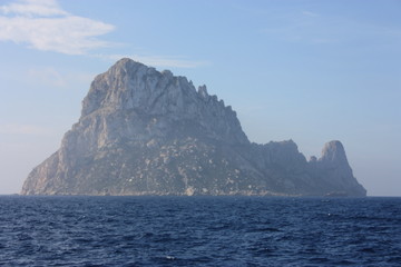 Fototapeta na wymiar the islet of Es Vedra among the mist on the blue water of the ibiza sea