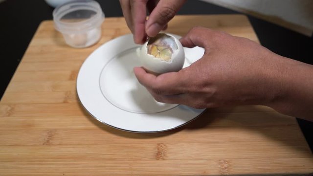 Peeling shell out of the duck egg before eating