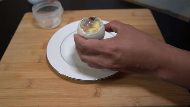 Sprinkling balut duck egg with salt before being eaten.