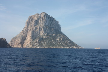 Fototapeta na wymiar the islet of Es Vedra among the mist on the blue water of the ibiza sea