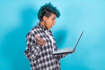 afro american girl with laptop computer isolated on blue background