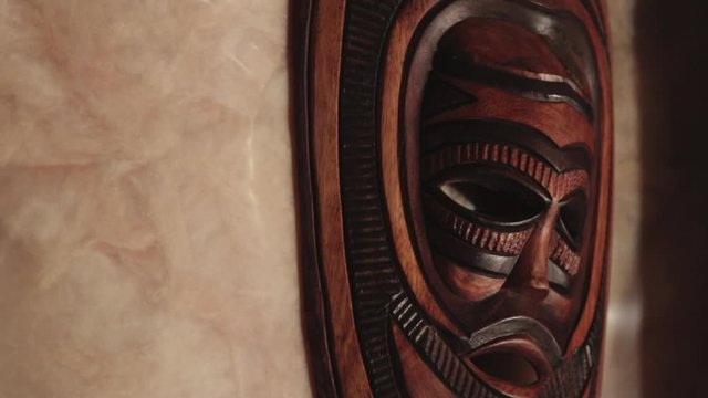 A Native Wooden Tribal Face Mask Hanging On The Wall - Close Up Shot
