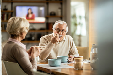 Senior man enjoying in breakfast with his wife at home.