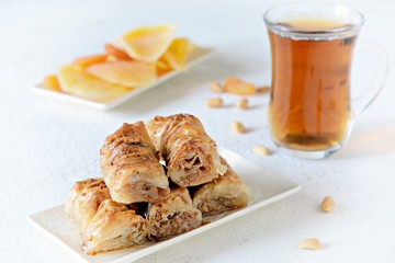 Turkish baklava dessert with walnut, peanuts, honey syrup with black tea and dried fruits, dried apricots and mango. Middle eastern or arabic dishes. Traditional arabic dessert
