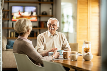 Happy senior man and his wife enjoying in breakfast at home.