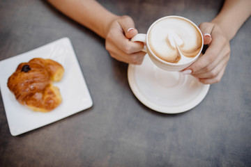 Woman eating coffee with delicious bakery.