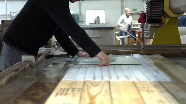 Preparing the glass panel on a table for cutting with automatic water jet CNC machine. Water jet cutter tool. An industry machine cutting glass with a robotic arm and water nozzles.