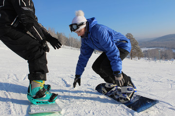 a girl studying snowboarding with an instructor on a ski slope
