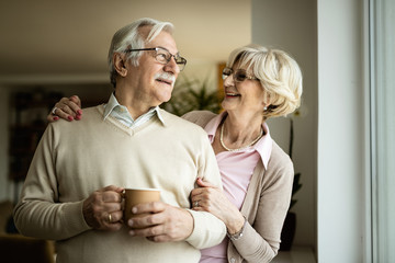 Happy senior couple talking to each other at home.