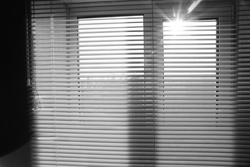 Sun shine outdoor. Window with blinds in the room.