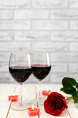 A glasses of wine, rose and burning candles