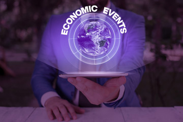 Writing note showing Economic Events. Business concept for transfer of control of an economic resource to another party Elements of this image furnished by NASA