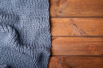 Fototapeta na wymiar knitted gray plaid on a wooden background
