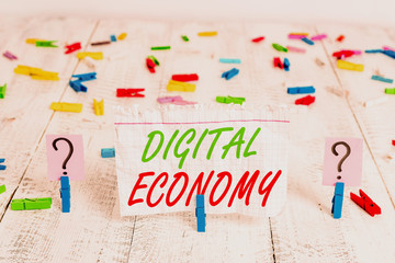 Writing note showing Digital Economy. Business concept for economic activities that are based on digital technologies Crumbling sheet with paper clips placed on the wooden table