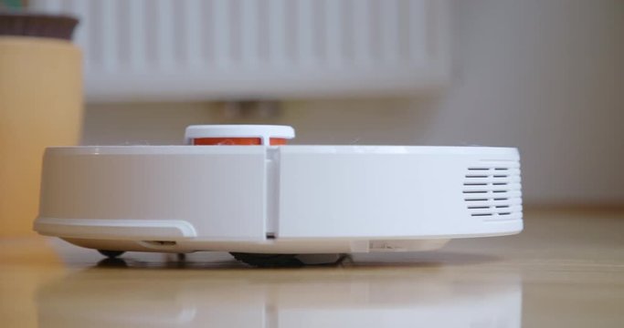 Robot cleaner cleans the room. Smart home. Robot vacuum cleaner performs automatic cleaning of the apartment at a certain time. 