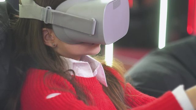 Little girl playing VR simulator with glasses