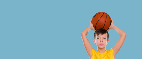 Kid playing with a basketball isolated on blue background
