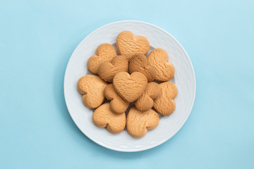  heart cookies in white plate on pink background