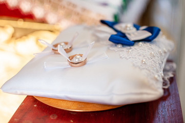 Pair of golden wedding rings on the white pillow