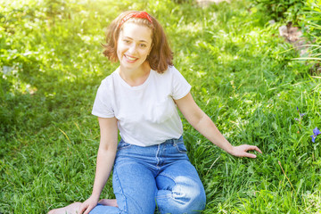 Happy girl smiling outdoor. Beautiful young brunete woman with brown hair resting on park or garden...