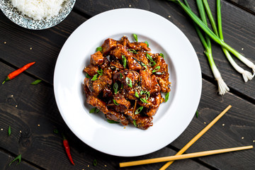 General Tso's Chicken closeup view from above. General Tso's chicken (also tsao or tao) is a popular chinese restaurant food with deep-fried crispy chicken covered in a tasty sweet and spicy sauce.
