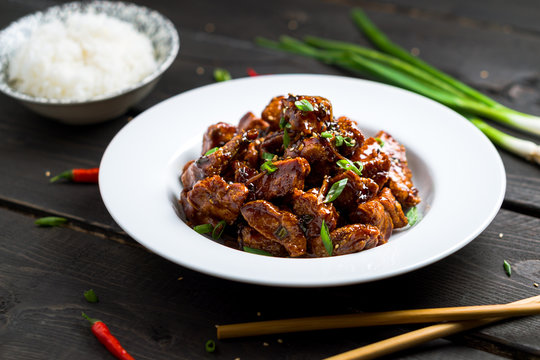 General Tso's Chicken dish low angle view. General Tso's chicken (also tsao or tao) is a popular chinese restaurant food with deep-fried crispy chicken covered in a tasty sweet and spicy sauce.