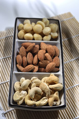 almond and cashew in the plate on the bamboo mat