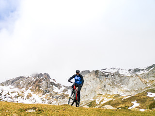 Naklejka premium Man riding a mountain bike in the snowy mountains