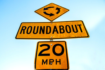 Yellow roundabout sign on a street