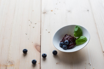 Jam of blueberries on a light wooden table for a delicious breakfast