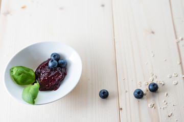 Jam of blueberries on a light wooden table for a delicious breakfast