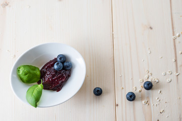Jam of blueberries on a light wooden table for a delicious breakfast