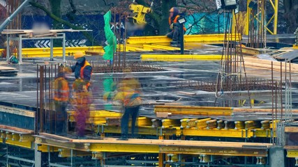 Group of construction workers at a construction site. Builders laying metal reinforcements for new floor slabs. Time lapse. Zoom effect