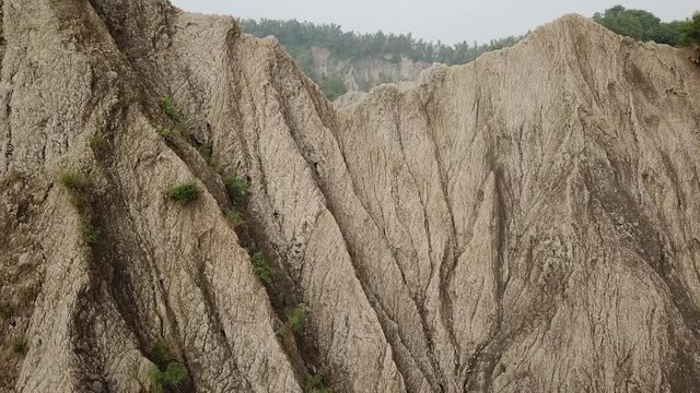 Stunning Aerial View and Flying Over Mudstone Cliffs in Tianliao Moon World Landscape Park, Taiwan Island