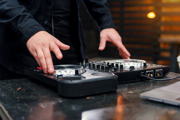 Close up of hands spinning the decks at the nightclub