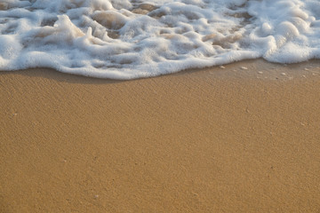 Fototapeta na wymiar Tropical beach background with soft wave and white foam