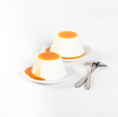 Italian dessert Panna cotta, creamy jelly with caramel sauce on a white background