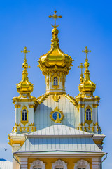 Fototapeta na wymiar Christian church with beautiful golden domes against the blue sky
