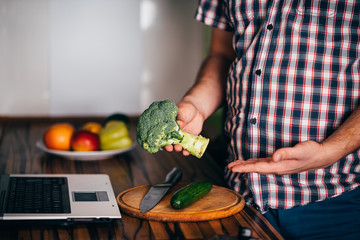 Overweight man recording video cooking healthy food at home kitchen. Cooking recipe online culinary blog, weight loss support