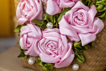 Close-up of artificial roses made from pink ribbons.