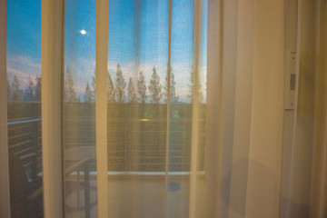 The blurred background of the white curtains attached to the balcony for viewing in the room, often seen in hotels or resorts in general, to impress the customers.