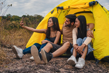 diverse people of caucasian and asian friends having fun together traveling and camping at natural park in summer