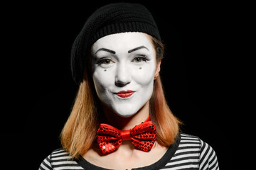 Cute female mime on black. Mime actress, dressed in striped t-shirt
